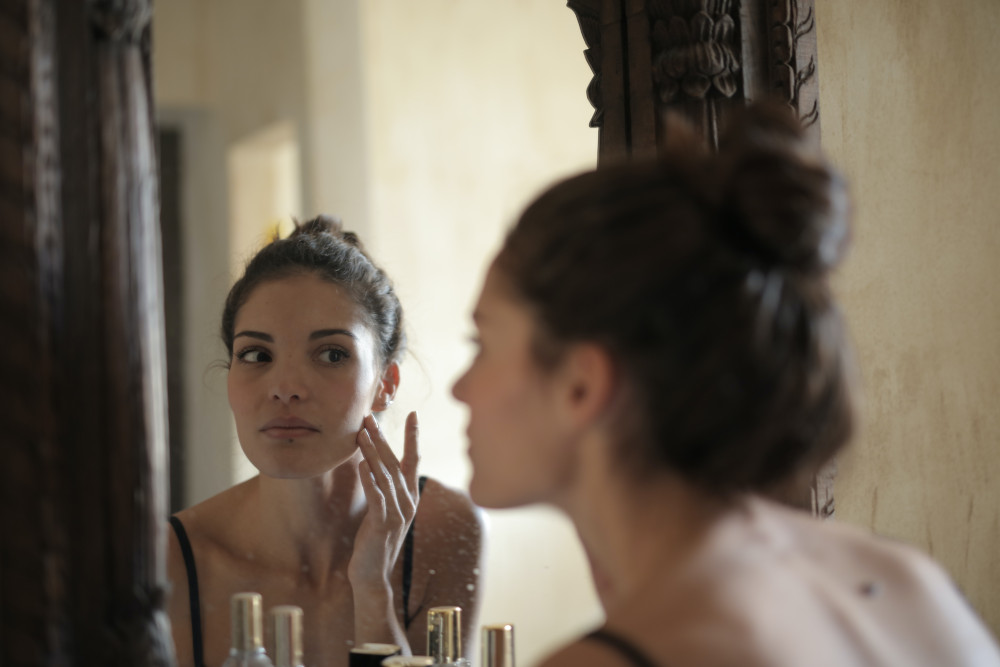 brunette woman looking in mirror